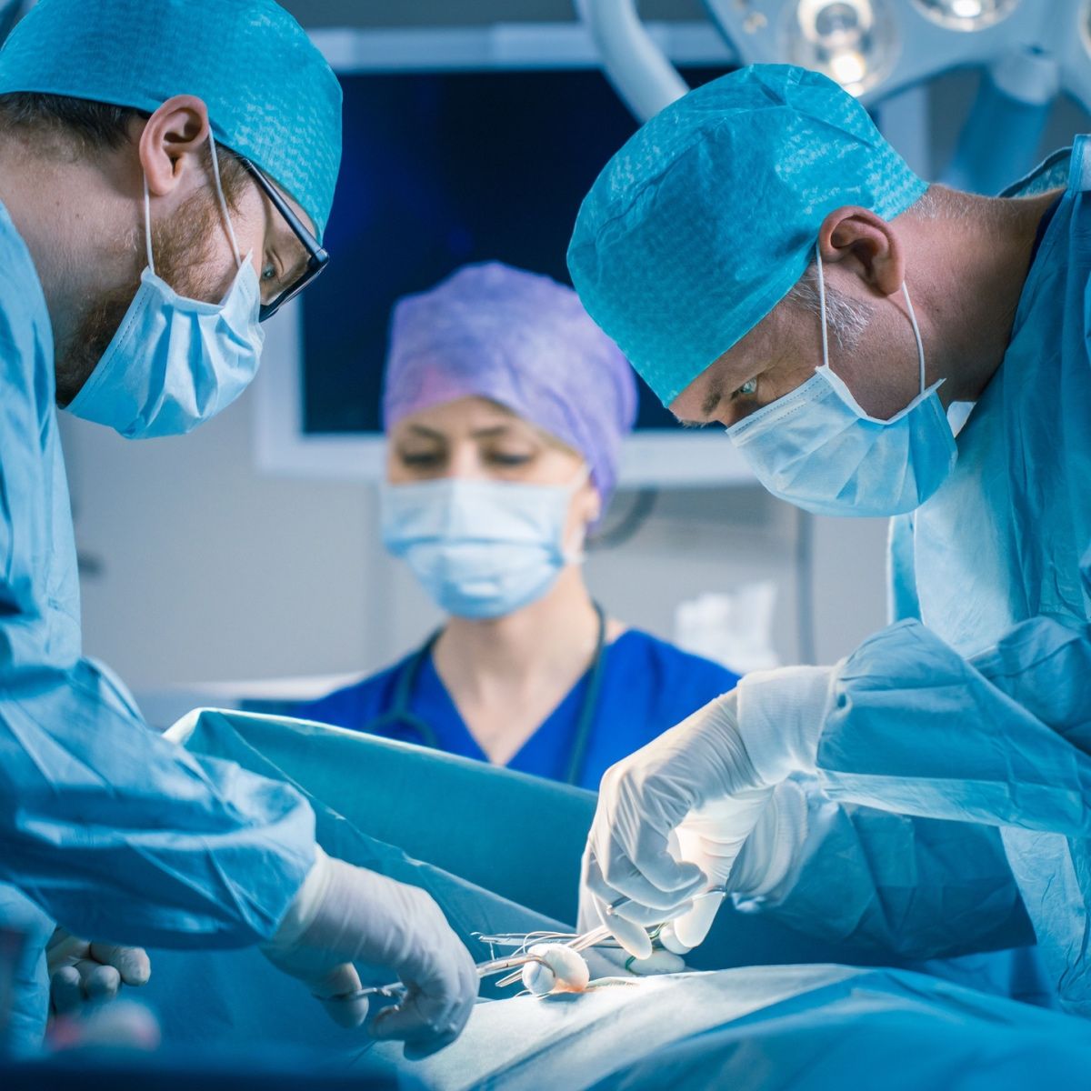 Surgeons performing orthopedic surgery using bone grafts