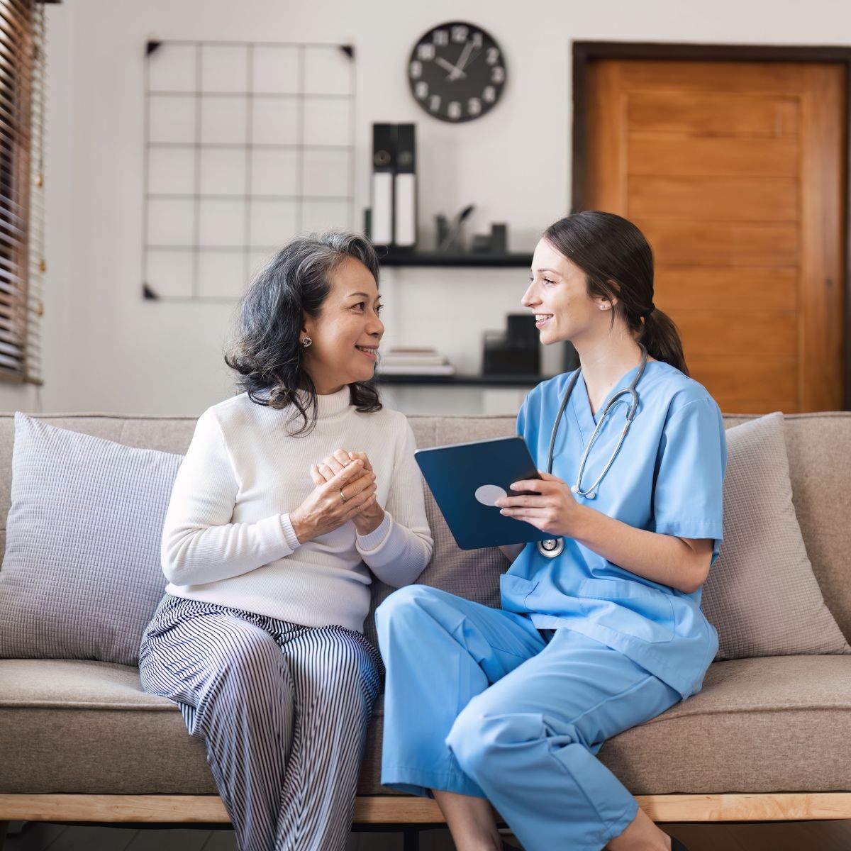 A nurse talking to her patient at home